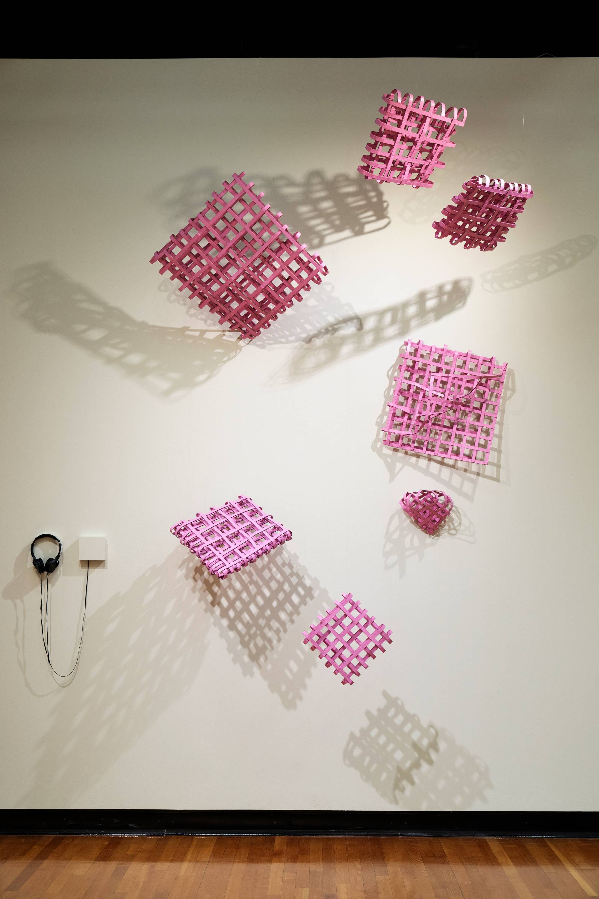 installation of woven squares of cardboard painted pink